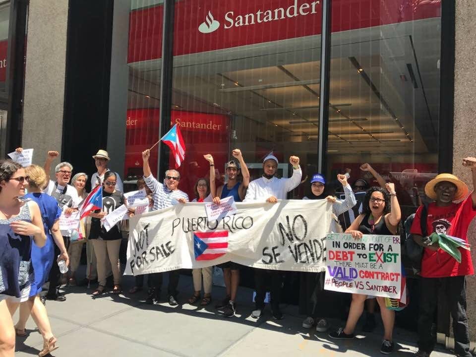 Un grupo de manifestantes frente a una sucursal del Banco Santander en Puerto Rico. Foto: David Galarza.